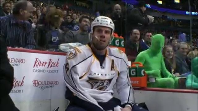 Root Suit fans, green men at hockey game mocking opposition players in full body spandex suits.mp4
