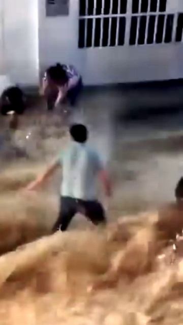 Парни пытаются удержать свои мотоциклы во время паводка в Перу