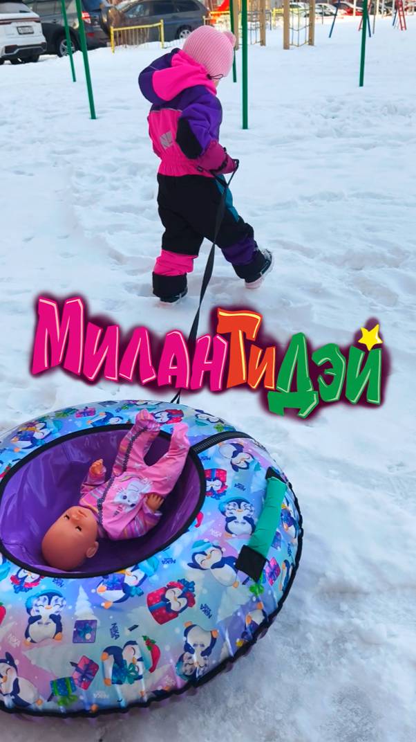 Милана катает малышку на ватрушке на горке на качелях