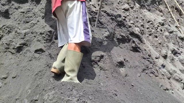 Строительство, шахтёры копают песок на чёрном утёсе