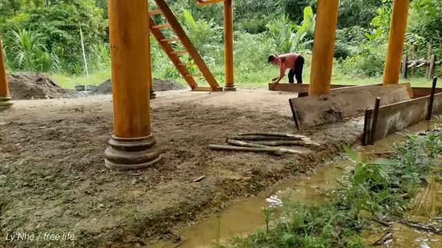 Girl with the technique of pouring cement and sand floors for a two-story wooden house. Ly Nhe