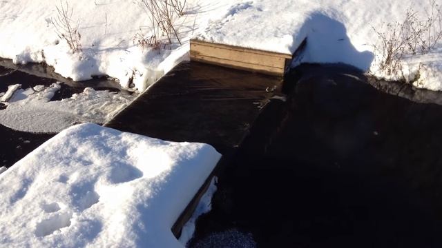 Солнечный день, ручей переливается через дамбу