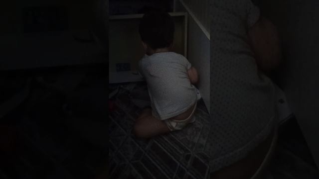 Ребенок вынул ящик в тумбочке и перебирает содержимое