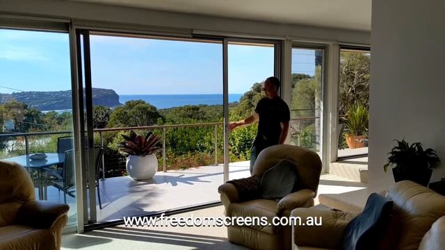 Infinity Zipline Retractable Screens on clear anodised stacking sliding doors.