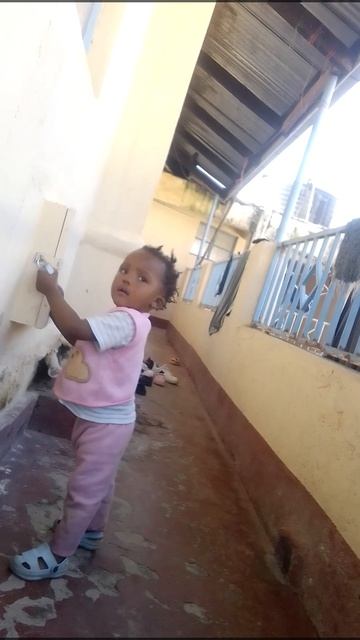 The kid is trying to open the padlock without keys