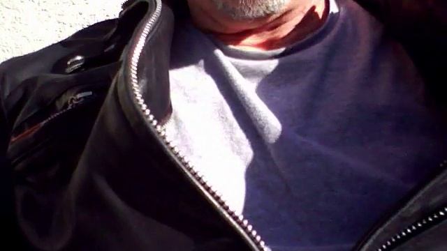 Smokin up close in black leather cafe racer jacket on a sunny warm winter day