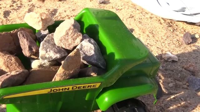 Грейдер и самосвал строят замок из песка. Vehicles on the beach