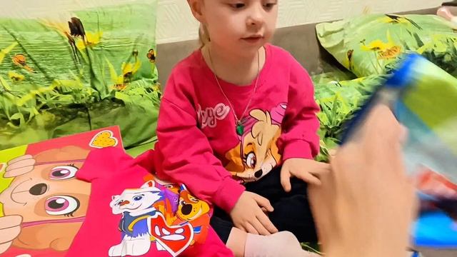 Милана раскрывает свои подарки.