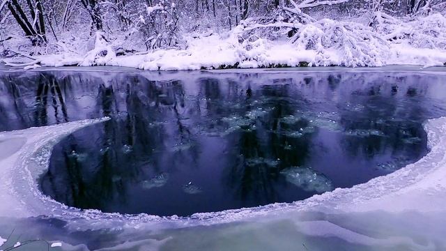 Водоворот на зимней реке. Идет спокойный снег. Холодная картина зимы. Релакс.