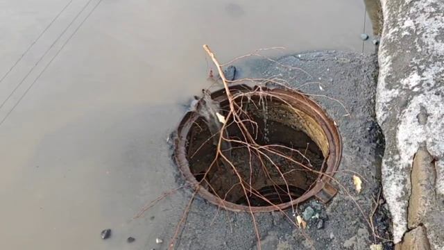 Вода стекает в открытый колодец.