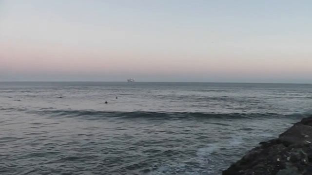Dusk and surfers at the end of the San Gabriel River in Seal Beach