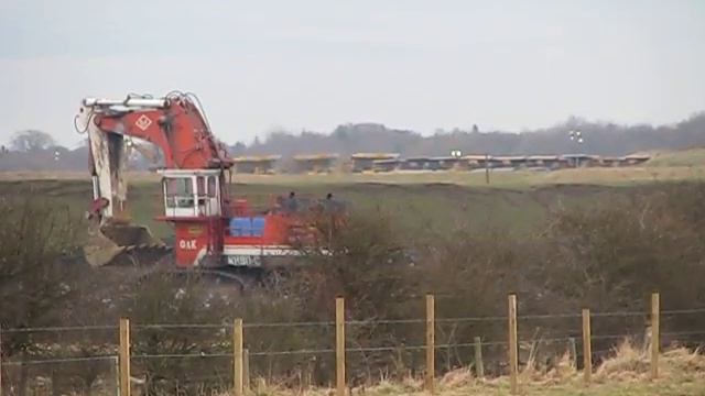 O&K terex RH 90 driving with the fleet of haul trucks starting up in the back ground