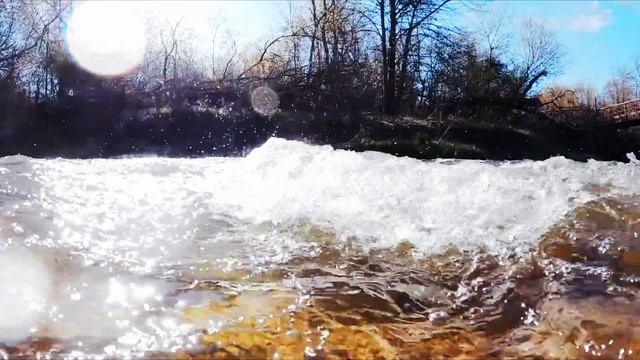 Бурный поток воды с пеной на реке весной.  Пение проснувшихся птиц. Природный ландшафт.