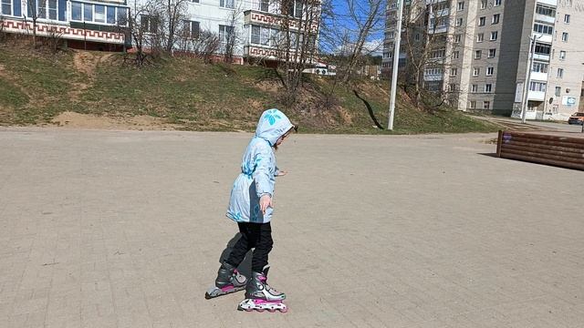Ника учится кататься на роликах.