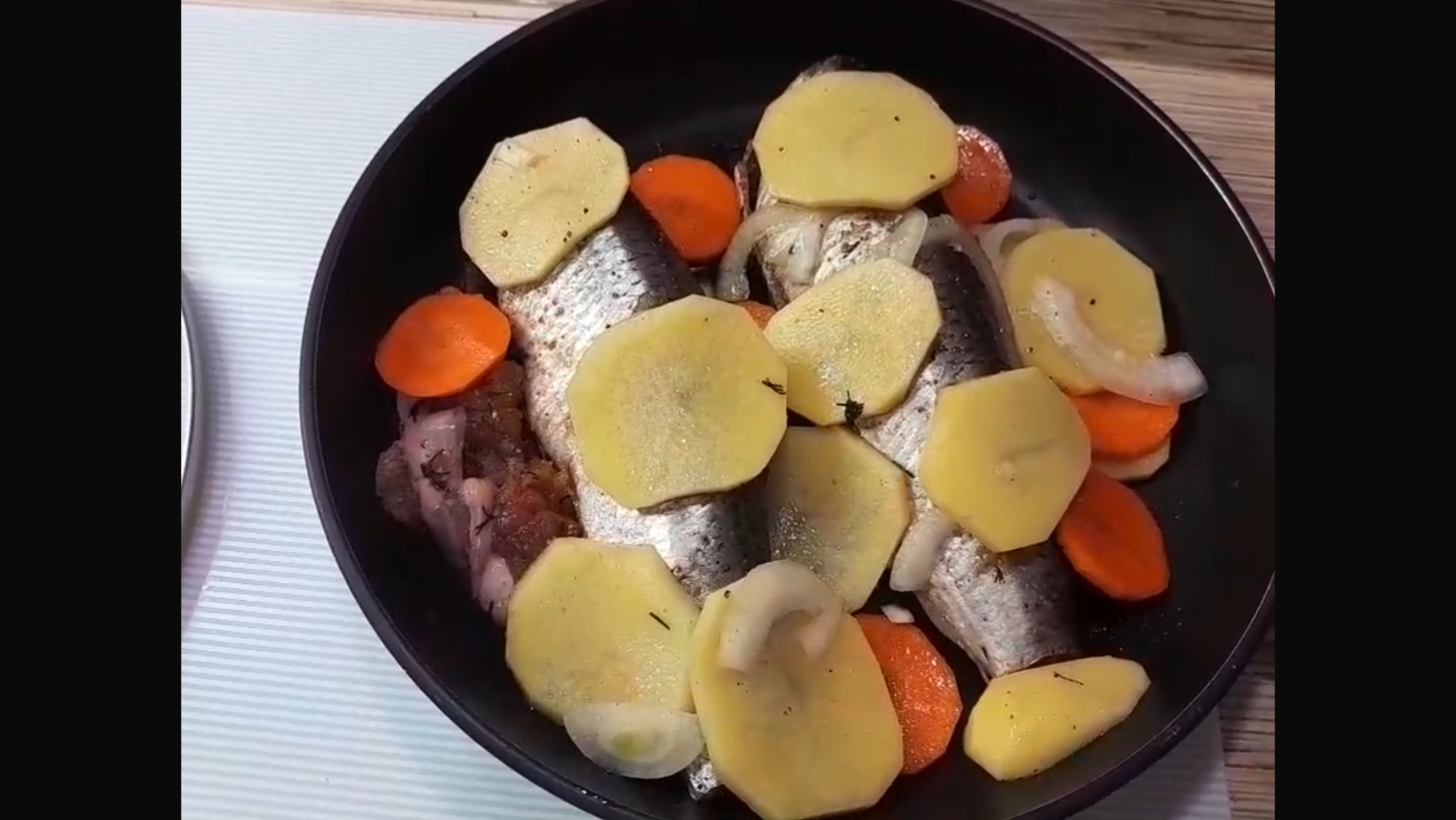 Жареная Селедка с овощами на сковороде.