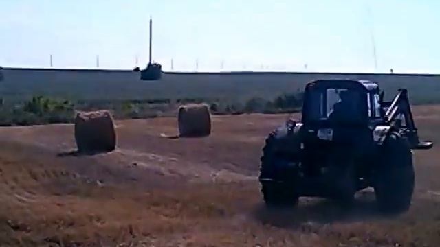 Погрузка тюков соломы в поле