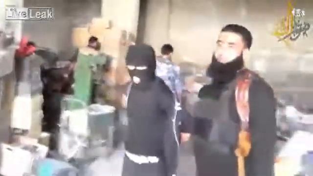 Syrian citizen soldiers walk captured regime loyalist gangster thief, Hasan Jazara around one of hi