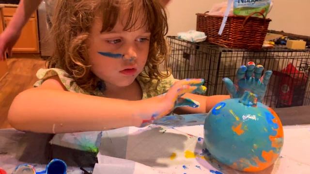 Ayla makes a mess painting faces on pumpkins!