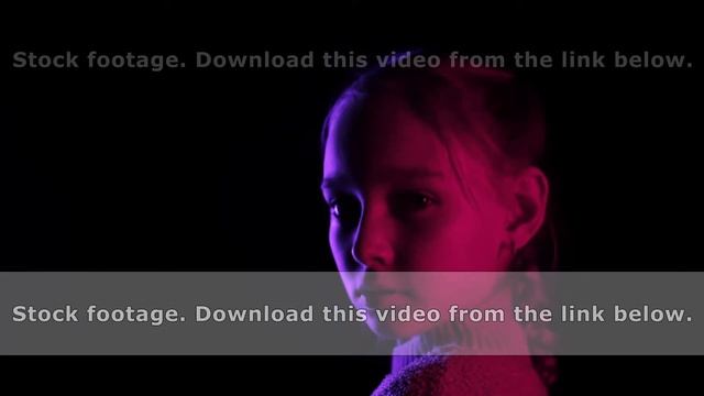 Teenager girl turning around on black background in neon lighting. Portrait young girl looking to