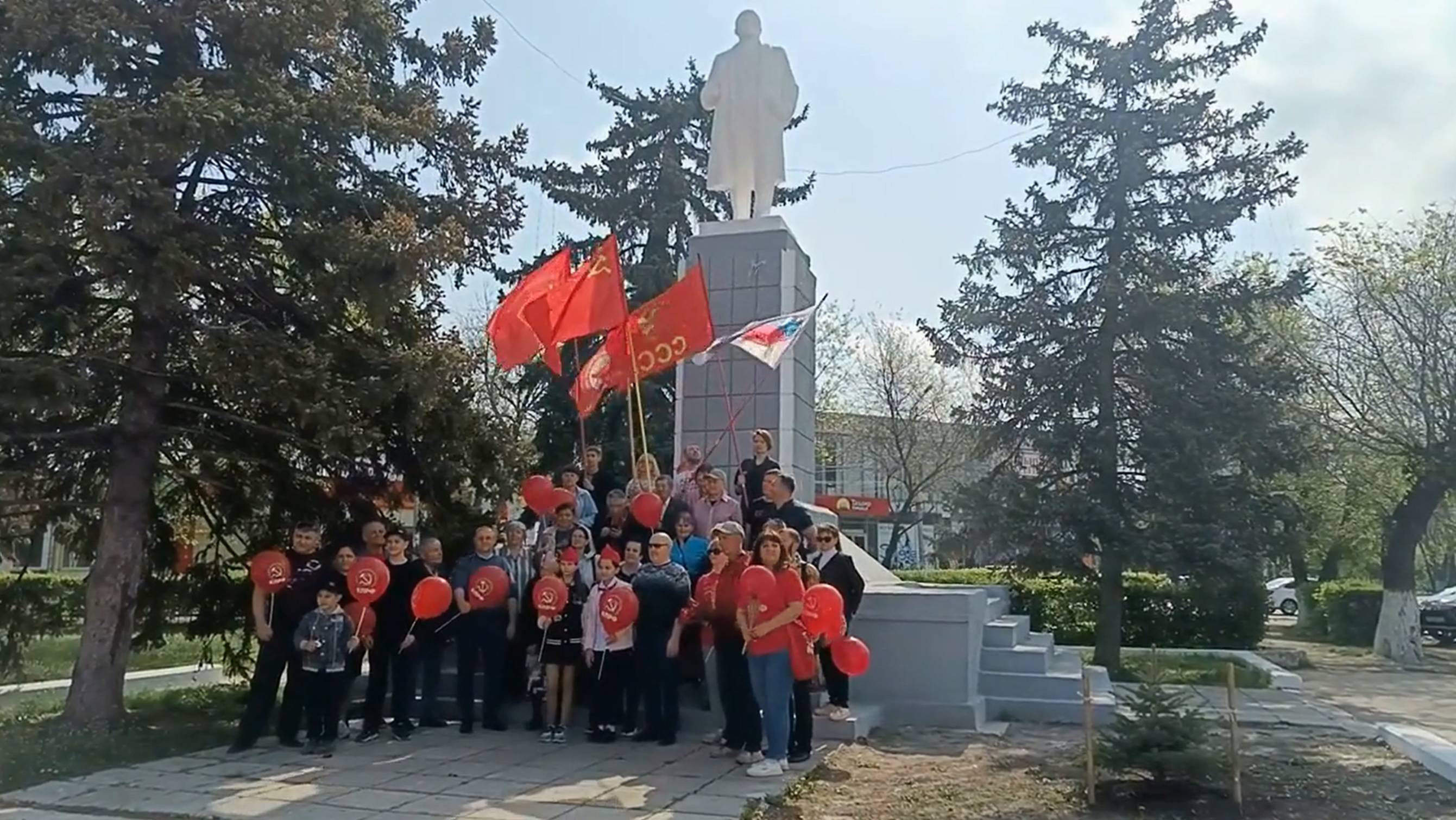 Коммунисты празднуют 1 мая у памятника В. И. Ленину.