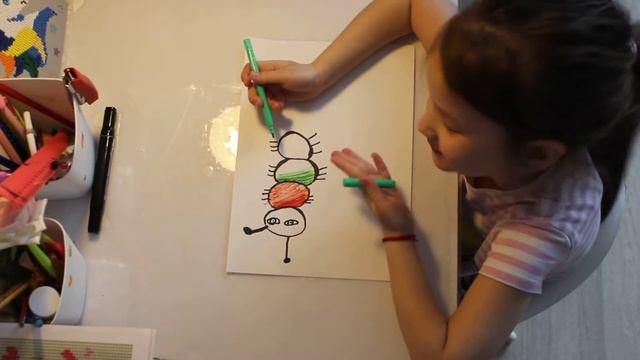 Даша Бананчик рисует маленькую гусеницу.
