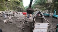 Строительство, экскаватор копает чёрный песок