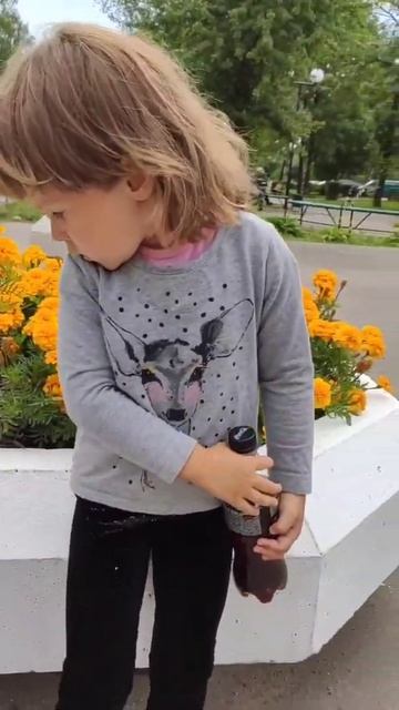 Маша возле клумбы с бархатцами на городской клумбе
