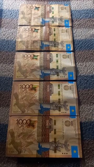 Пять БАНКНОТ 1000 ТЕНГЕ на байковой поверхности 31-ого Де