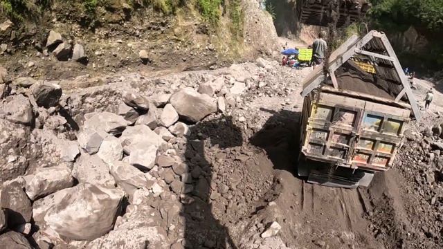 Строительство, экскаватор копает чёрный песок