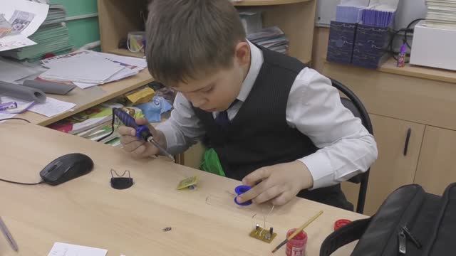4А класс 13 школы занимается пайкой схемы мультивибратора.