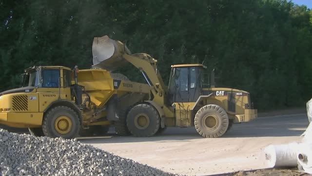 Погрузчик Cat 962G грузит самосвалы Volvo A30E