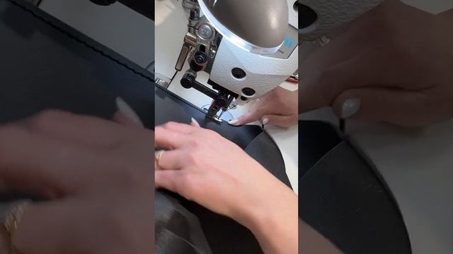 Швея шьёт оплетку на руль на мощной машине.