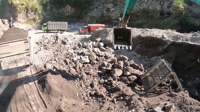 Строительство, экскаватор копает чёрный песок