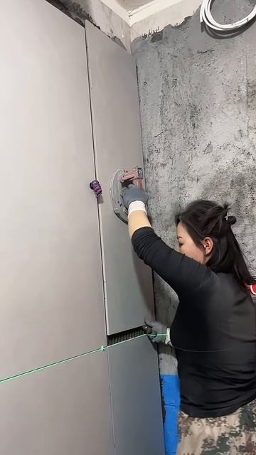 The process of installing tiles on the wall is carried out by female workers #shorts