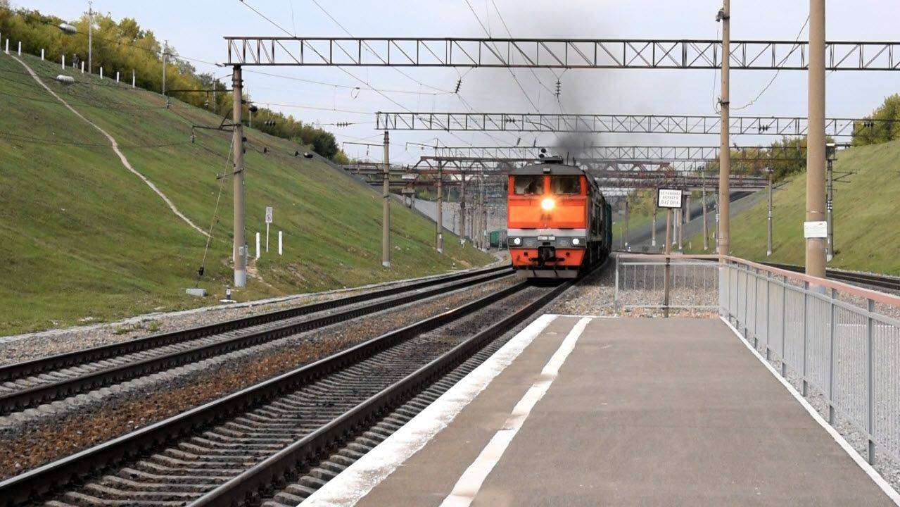 Тепловоз 2ТЭ10М-2668 на подъёме с сочленёнными крытыми вагонами.