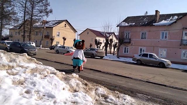 Заяц помогает надеть штаны Медведю на празднике