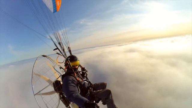 Параплан с мотором, полёт над облаками. Paraglider with a motor, flying over the clouds. Paramotor.