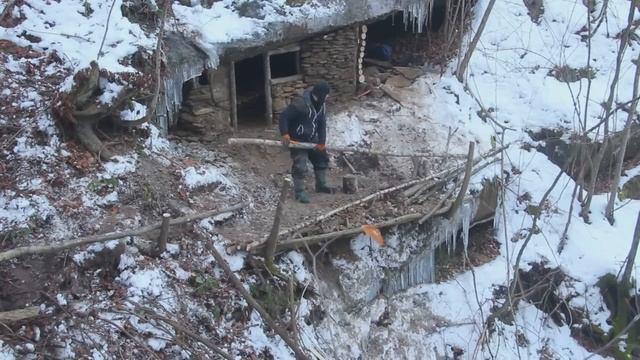 Мужчина СТРОИТ потаиное убежище под скалои зимои