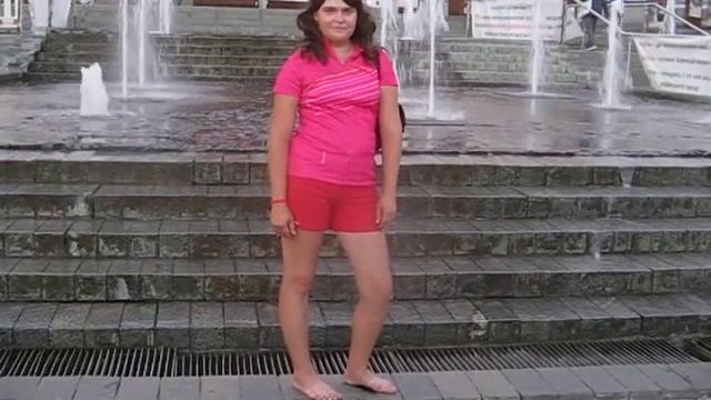 Босая девушка в красной футболке и фонтаны