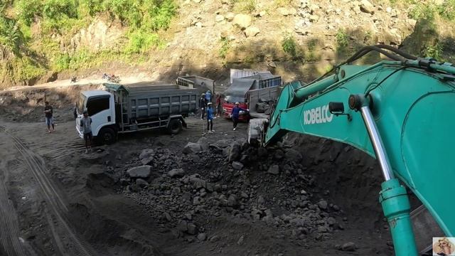 Строительство, экскаватор копает  чёрный песок