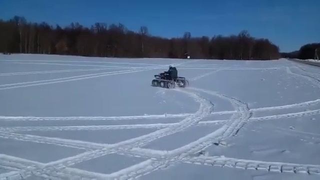Тест -драйв по заснеженному полю, гусеничный вездеход.