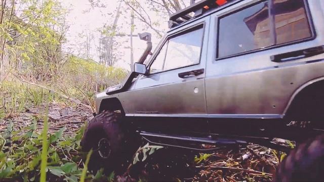 Радиоуправляемый Jeep Cherokee XJ катается по травке.