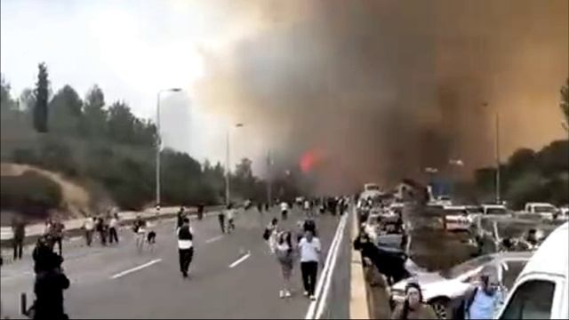 Люди бегут от приближающего пожара в Канаде