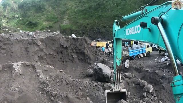 Строительство, экскаватор копает чёрный песок