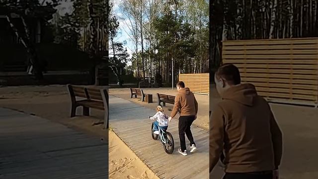 Папа учит дочку кататься на велосипеде