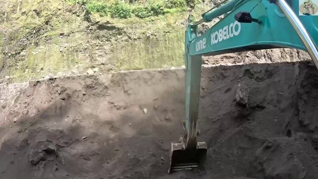 Строительство, экскаватор копает чёрный песок