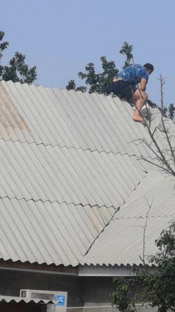 Человек ремонтирует крышу.