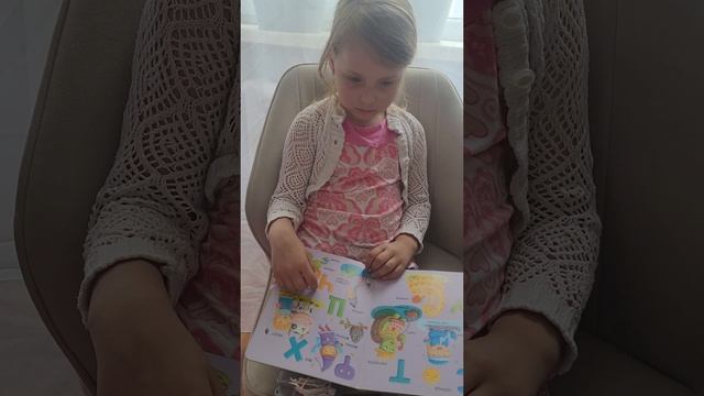 Арина повторяет буквы.