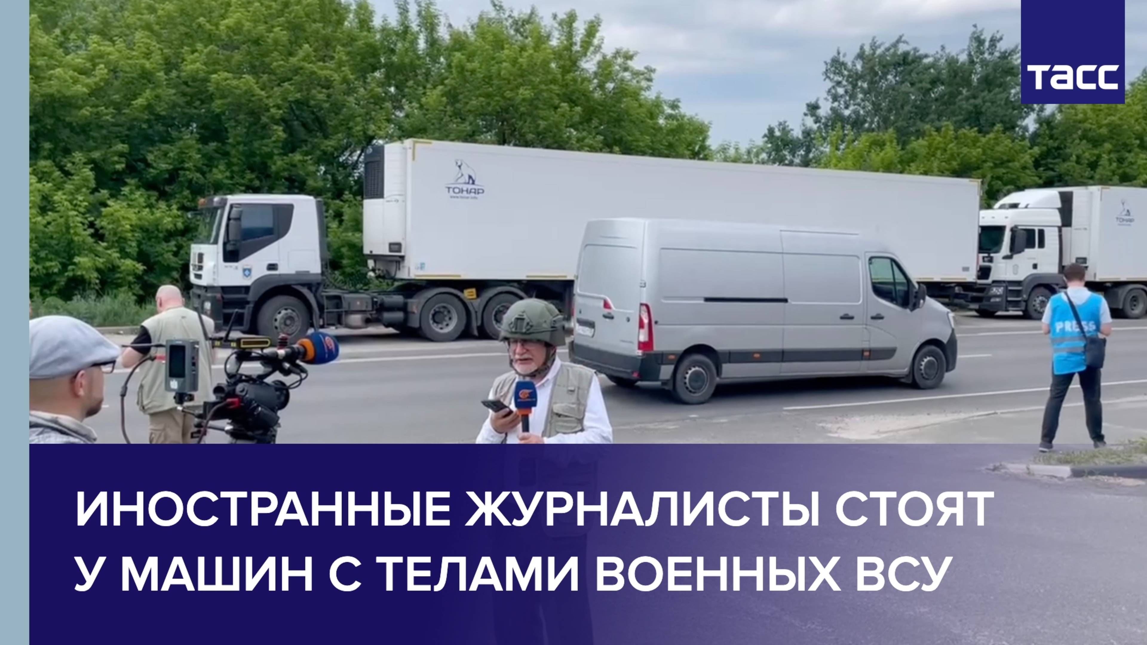 Иностранные журналисты стоят у машин с телами военных ВСУ