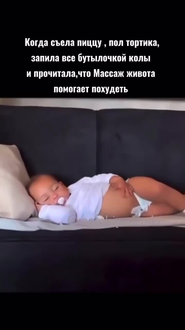 Ребенок с соской лежит на диване и гладит свой живот 😍